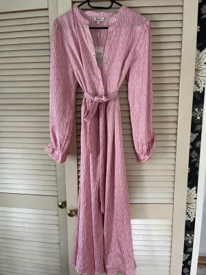 Mönstrad klänning - Oanvänd Klänning köpt i Köpenhamn i somras.Justerbar midja med rosa och lila mönster på.Nypris 1100kr