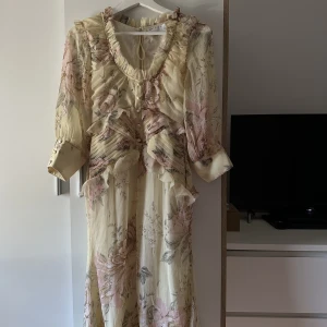 Blommig midiklänning med knappar och rå fåll- Asos design - I nyskick och oanvänd. Beställd från Asos. Storlek 36 men skulle nog säga att det är en 34.