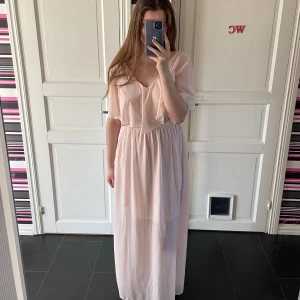 Ljusrosa långklänning - En ljusrosa långklänning perfekt till skolavslutningen. Strl: S,36. Passar mig som i vanliga fall har strl:38. Stretch i midjan med resårband. Går nästan hela vägen ner till fötterna på mig som är 173cm lång🩷