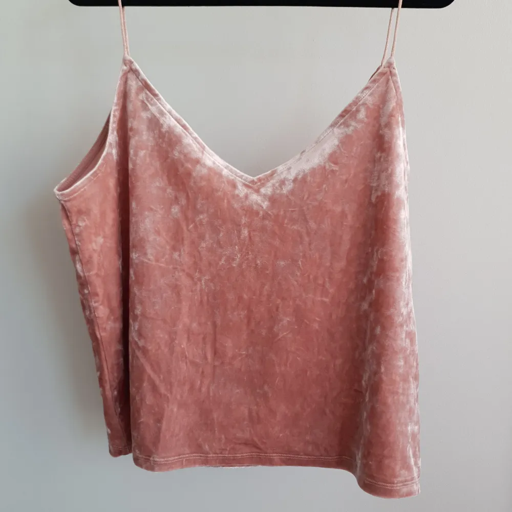Rosa linne i ett sammetsmaterial med v-rigning. Har använts ett fåtal gånger och är i ett fräscht skick.. Toppar.
