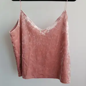Rosa linne i ett sammetsmaterial med v-rigning. Har använts ett fåtal gånger och är i ett fräscht skick.