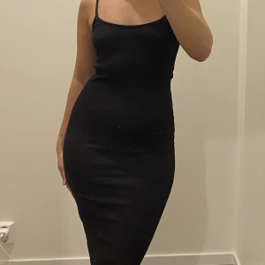 Svart klänning - Klänning som formar kroppen. Stretchigt ribbat tyg. Gammal klänning som är använd men ser fortfarande fräsch ut