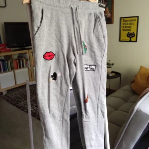 Grey sweatpants with decorative designs. - Mjuka grå mjukisbyxor med påsydda designs.  Byxorna är i gott skick.
