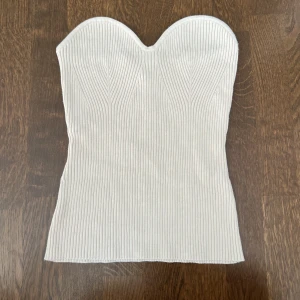 Ribstickad tubtop - Ribstickad vit tub top från H&M. Storlek L men passar även M. Köptes för 299kr. 