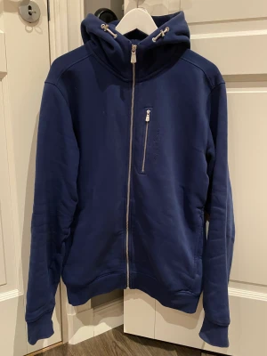 Sail racing zip hoodie  - Sail racing zip hoodie. Mörkblå färg, storlek Large. Tröjan är i jätte fint skick sparsamt och sällan använd då den var lite förstor redan när jag köpte den. Köpt ny i sail racing affär för ca 1300kr. Bara att skriva vid frågor och funderingar. 