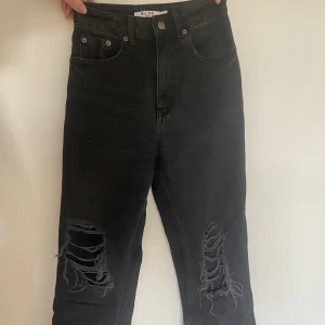 Raka jeans med hål - Svarta raka jeans med hål från NAKD.