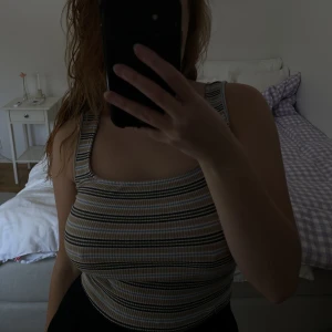 Randigt linne - Beige,-blått,-grönt & vitrandigt linne från Urban Outfitters. Väldigt fint skick, dock har lite av sömmen gått upp längst ner (innanför) + ett litet hål - men syns inte när man har på sig linnet. Storlek M men sitter mer som S, väldigt stretchigt