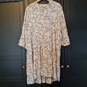 Blomstrande klänning - Vit klänning med blommigt mönster. Sval och köpt på lokan marknad. Nyskick