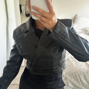 CROPPAD SKINNBLAZER - croppad blazer i skinn med knäppning, använd 1 gång 