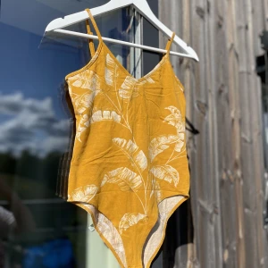 Gul body - Söt body från HM med diskret växtmönster