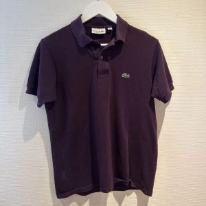 Lacoste pike - Säljer denna as snygga Lacoste piken, den är väldigt snygg i sin unika röda färg, den är använd men fortfarande i nyskick 9/10 Tveka inte på att höra av er om ni har några funderingar 