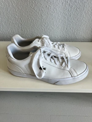 Vita sneakers Lacoste skinn - Säljer min vita lacosteskor. I nyskick och endast använda på studenten men för små för mig. Strl 40 men funkar även för 39. 