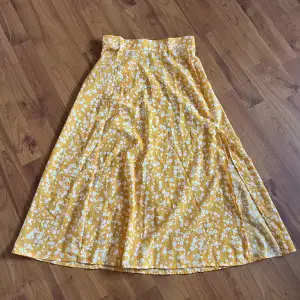 En gul blommig kjol med slits från SHEIN. Storlek XS, är till mitten av vaden på mig. Är 160💞 Aldrig använd, nyskick. Skriv för mer bilder🥰
