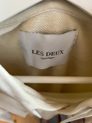 Les deux hoodie - En beige hoodie av märket les deux i bra skick. Det står att den är storlek XL men den är väldigt liten i storleken så den sitter som M. 
