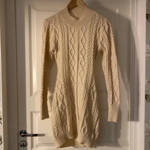 Stickad klänning - Super fin stickad klänning, perfekt nu under höst/vinter, har dessvärre ett hål precis där sömnen är på ena sidan (se bild 2), men kan sy ihop det innan jag postar:) naturvit färg, vet inte storlek, men gissar på s/m
