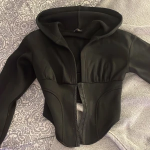 Topp - Detta är en topp med korsett spännen runt midjan, fin i skicket och kanppt använd (använd ändast 3 gånger) super skön och mysig topp att bära