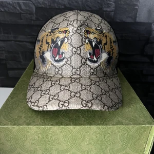Gucci keps  - Säljer en gucci tiger keps  Storlek L Kepsen är i bra skick  Tags, kvitto dustbag och kuvert fås med.  Kom med bud annars 3000kr Först till kvarn