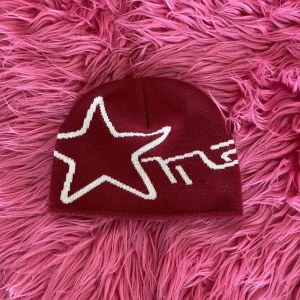 Beanie med stjärna - Röd beanie med stjärna på! Kommer sitta fint på din knopp.