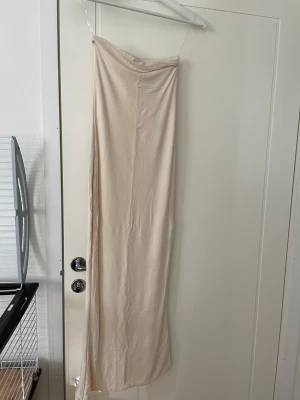 OhPolly klänning  - Bandeau långklänning i färgen Ivory köpt från OhPolly, endast använd 1 gång så den är i perfekt skick. 