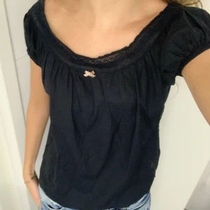 Odd molly topp - Mörkblå Oddmolly topp med liten rosett längst fram, spetsdetalj längs kanten och liten puffärm. Är lite ljusare i verkligheten än på bilderna💗