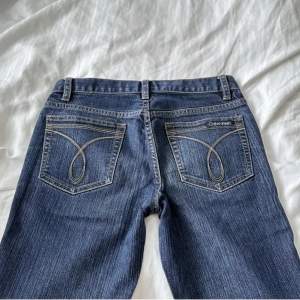 Super snygga low waist flare jeans i mörkblå från calvin klein i bra skick.  Skulle säg att de är storlek 32/34! Innerbenslängd: 74cm  Midjemått: 34cm tvärs över   Har 32 i jeans och dessa är en anning lite för stora 