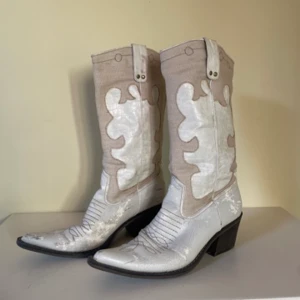 Vita cowboy boots - Vita cowboy boots stl 39 från märket gyllene gripen, de är otroligt sköna att gå i men tyvärr har de fått små skador efter användning i den ljusa lädret nere vid foten:( förmodligen för de är så gamla