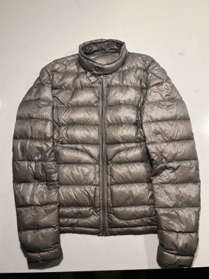 Moncler acorus  - där finns ett hål på sidan av jackan under armen, men de är fixat med en lagningslapp, så det syns inte alls när man använder jackan! Ställ gärna frågor🤩 