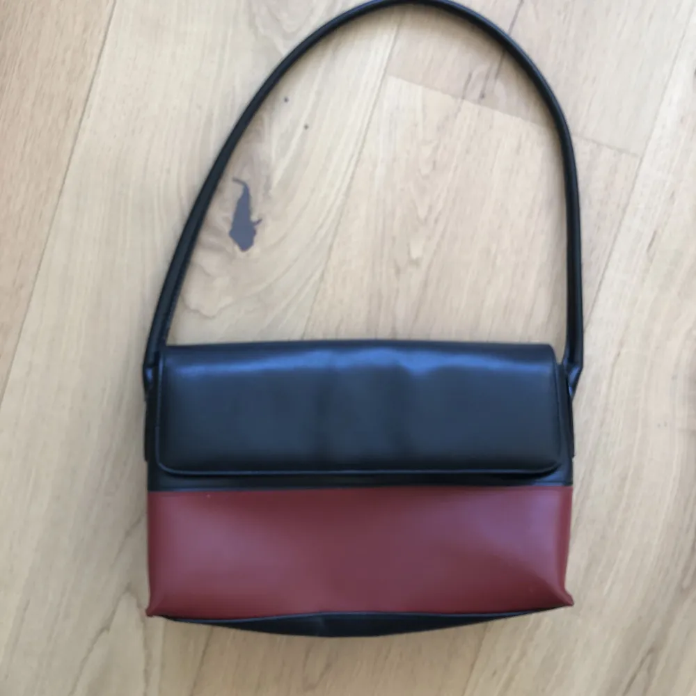 Mindre väska röd/svart. B28xH19xD8. handtag ca 70 cm. Väskor.