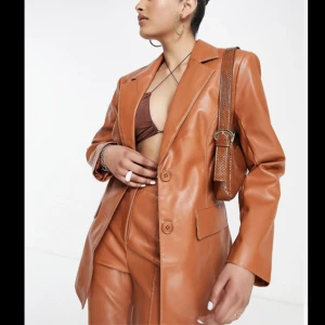 Helt ny läderjacka/kostymjacka (prislapp kvar - Oanvänd figursydd kostymjacka i läderimitation.  Ursprungligt pris: 789 kr