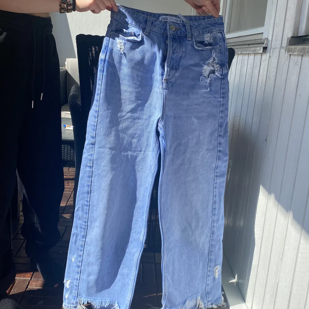 Ett par blåa baggy jeans som är perfekta inför sommaren. Några små hål på byxorna och slitet längst ner  ( modellen är så ) . Jeans & Byxor.