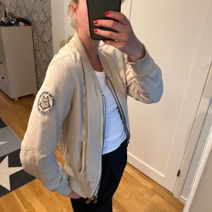 Zadig et Voltaire bomberjacka - Zadig et Voltaire bomberjacka med dubbla dragkedjor i storlek S i beige. Jackan är använd en del och har därför lite skiftningar i färgen men är i övrigt i bra skick. Nypris 2700 kr, säljes för 500 kr + frakt. Kvitto finns från Zadig et Voltaire.
