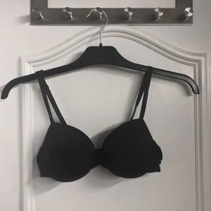 Svart BH - En svart BH med liten söt rosett mellan bysten. Den är i bra skick och använd få gånger. 