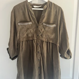 Grön klänning från zara med silverdetaljer - Grön klänning från Zara med silverdetaljer. Använd ett fåtal gånger. Frankt ingår ej. 