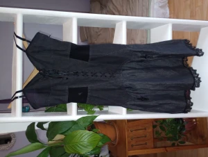 Moschino denim klänning med spets och korsett  - En vacker figursydd denim klänning med klockad kjol nertill som avslutas med svart spets. Smörad som en korsett upptill vilket gör den flexibel tillsammans med en dragkedja i sidan. Den har sexiga detaljer som påminner om strumpeband fram och bak.