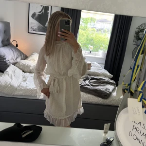 Cremevit klänning  - Jättefin cremevit klänning med svarta prickar på. Knytning i midjan och volanger längst ner på ärmarna💖