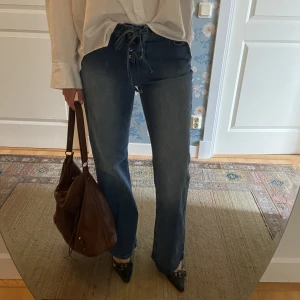 Jeans med snörning i midjan  - Skitsnygga jeans med snörning i midjan som ger en unik touch. Jeansen har endast blivit använda en enda gång och är därför i nyskick!☺️Säljer dem eftersom de inte används. Jag minns inte det exakta orginalpriset men vet att det låg på minst 500kr. 