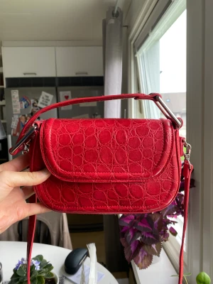 Röd handväska - Röd handväska från zara. Sparsamt använd och i mycket bra skick ☺️väskan har ett kortare och ett längre band som går att justera efter önskad längd!