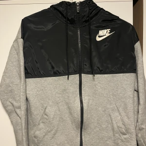 Grå Nike luvtröja  - En grå nike luvtröja. Två olika färger med olika material. Använd fåtal gånger. 
