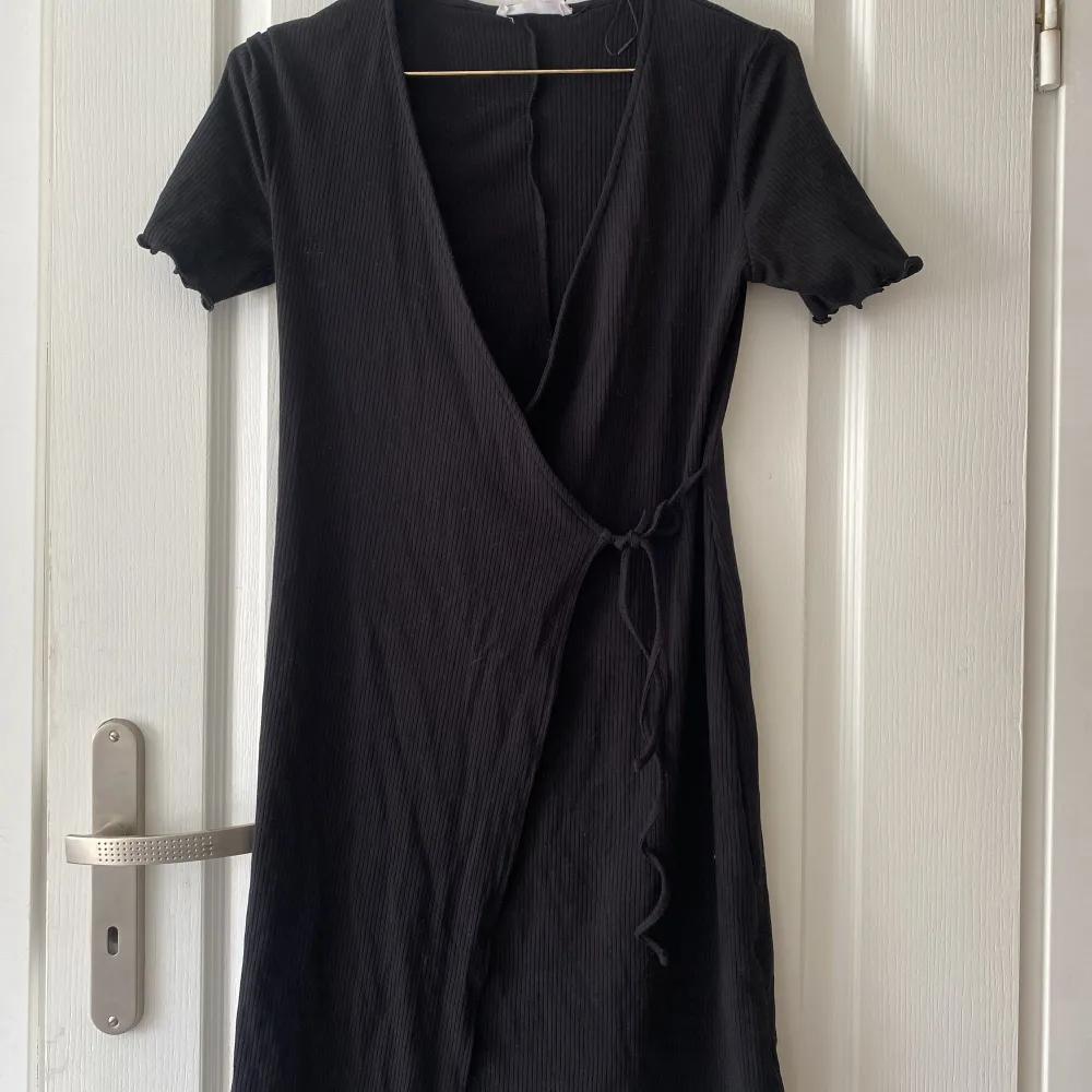 Säljer en svart omlott klänning från primark som används en gång. Säljer pågrund av att den inte sitter så bra.. Klänningar.