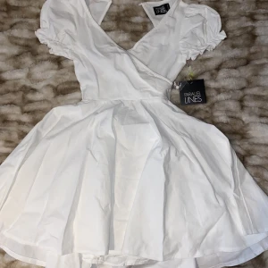 Vit klänning - Säljer en söt vit klänning som jag tänkte ha på studenten, men hitta en annan. Klänningen har prislappen kvar med öppen rygg, men knappen bak är sönder. Däremot medföljer det en knapp man kan sy på! För fler bilder eller information hör av er💗