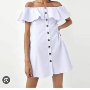 En vit off shoulder klänning från Zara med knappar på framsidan och fickor på sidan. Storlek S, frakt tillkommer.