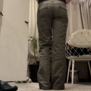 Cargo jeans - Skitsnygga byxor som är perfekta till sommarn! De har dubbelknapp fram vilket är en fin detalj! De är i grågrön och har snygga fickor! De är i storlek 28/29 i midja och passar i längd på mig som är 168!