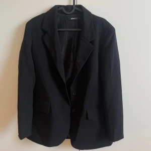 Svart kavaj  - Svart kavaj från Gina Tricot i storlek 36. Modellen är lite figursydd, så inte oversized. Säljs pga för lite för mig, och nästintill oanvänd. 