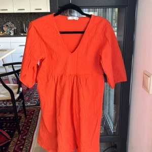 Klänning med fin ärm - Orange t-shirtklänning i snygg orange färg, använd endast en gång, fina ärmar, härlig orange.