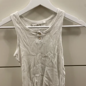 Vitt linne - Fint vitt ribbat linne som använts flitigt. Fortfarande bra skick. Finns en liten mörk fläck vid knapparna (kan skicka fler bilder). Storleken är 9-10 år, men passar mig som är 16 år och vanligtvis har xs-s i storlek. 