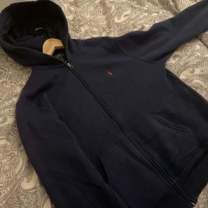 Kofta/hoodie/siphoodie - Detta är en tröja från ralph louren som jag väljer att sälja då den är för stor,köpt för ca 1 månad sen original pris 1500. Strl m.