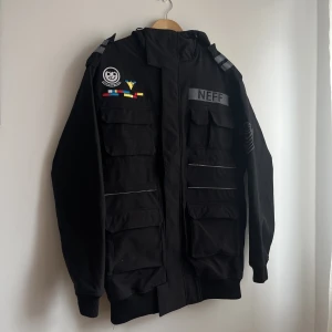 Snowboard/skid/vinterjacka från Neff, medium - Använd men mest hängt på vinden de senaste åren, men är i fint skick. Hänget på dragkedjan saknas det en bit av, men jackan går utan problem att stänga.  Medium. Massor av fickor både på framsidan samt några i bak. Muddar på ärmarna. Öppen för prisförslag