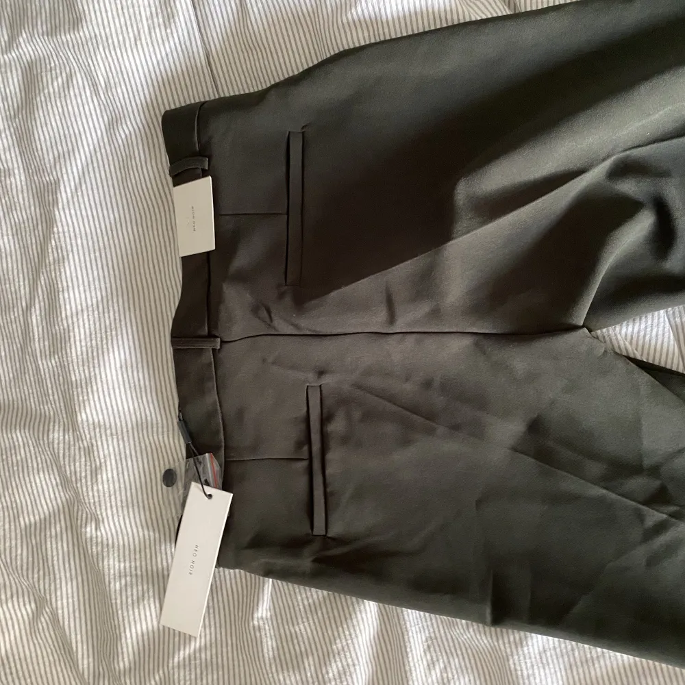 Super fina helt nya kostymbyxor från Neo Noir. De är mörkgrön/gråsvarta, jättesvårt att beskriva färgen och få den på bild. Säljs pågrund av att dom är för stora för mig De är i storlek S Helt nya aldrig använda!. Jeans & Byxor.