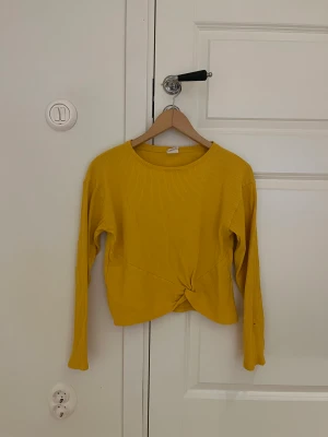 Tröja - Gul långärmad tröja. Fläck på ena ärmen.