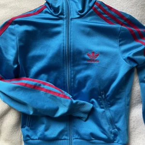 Adidas tröja - Säljer denna jättefina blåa och rosa adidas tröja i superfint skick! Kom privat för fler bilder! Köparen står för frakt💞💘